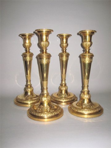 A HIGHLY IMPORTANT & RARE SET OF FOUR COPPER GILT CANDLESTICKS, ENGLISH CIRCA 1805. BEARING THE ARMS OF John Arbuthnott, With opposing Royal Coat of Arms & Royal Cypher to the Sconces. - Click to enlarge and for full details.